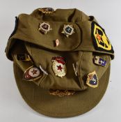 Russian khaki cap with assortment of badges attached