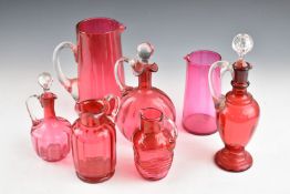 Seven pieces of cranberry glass including jugs, ewers and decanters, largest 29cm tall.