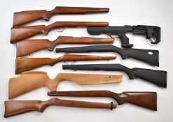 Ten various rifle stocks including BSA, one with a composite tactical stock.