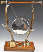 Victorian novelty taxidermy interest gong, the stand formed by two antlers and a riding or hunting