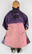 Chinese 'Door of Hope' doll wearing a red robe, purple silk jacket and cream under trousers,