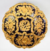 Meissen large shaped pedestal dish with relief moulded decoration of gilded flowers against a navy