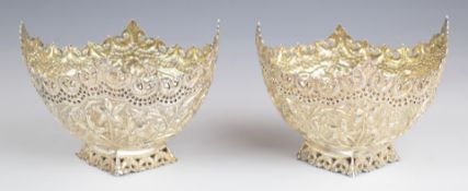 Pair of Burmese or similar silver bowls with embossed floral and foliate decoration, length 11.