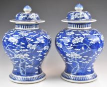 Pair of 19thC Chinese covered vases decorated with prunus blossom, with four character marks to