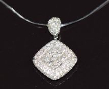 An 18k white gold pendant set with nine princess cut diamonds surrounded by diamonds, on 18k white