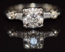 A 14k gold ring set with a round cut diamond of approximately 0.3ct and baguette cut diamonds to