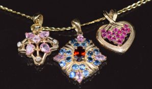 Three 9ct gold pendants one set with pink sapphires, topaz and paste, one with pink sapphires and