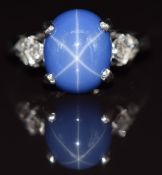 A 14k white gold ring set with a Ceylon star sapphire cabochon and diamonds to the shoulders, 4.