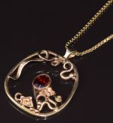 A 9ct gold pendant set with a garnet in an abstract design, on 9ct gold chain made up of box