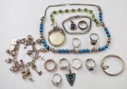 A collection of silver jewellery including five rings, magnifying glass, bracelet, charm bracelet,