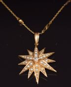 Edwardian 18ct gold pendant in the form of a star set with a diamond surrounded by seed pearls, on