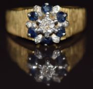 An 18ct gold ring set with diamonds and sapphires, with bark effect textured shoulders, 5.3g, size