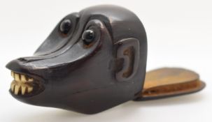 An 18th/19thC carved hardwood figural baboon or monkey snuff box with bone teeth and glass eyes,