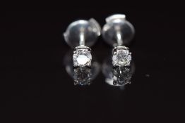 A pair of Tiffany & Co platinum earrings each set with a round brilliant cut diamond of