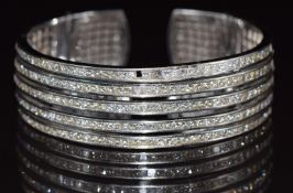 An 18ct white gold bangle/ cuff set with five rows of princess cut diamonds, the total diamond