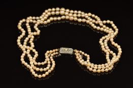 A triple strand of cultured pearls with a 9ct white gold clasp set with diamonds and a further