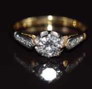 An 18ct gold ring set with a diamond of approximately 0.6ct and further diamonds to the shoulders,