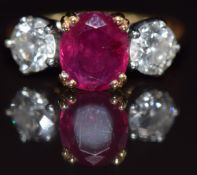 An 18ct gold ring set with an oval cut ruby of approximately 1.5ct and two diamonds, each