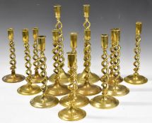 Fourteen brass hollow twist candlesticks, mostly pairs, height of tallest 37cm