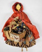19thC Grodnertal painted wooden Eastern pedlar doll wearing a red cloak and a basket with her