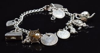 Silver charm bracelet with ten silver charms including handbag opening to reveal contents by Nuno,