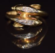 An 18ct gold ring in the form of two dolphins set with ruby eyes and diamonds, 3g, size M