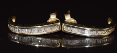 A pair of 10k gold earrings set with baguette cut diamonds, 2.6g