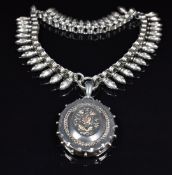 Victorian silver locket with applied gold decoration (Birmingham 1882) in a floral design, on a