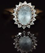 A 9ct gold ring set with an oval cut aquamarine surrounded by diamonds, 2.2g, size K/L