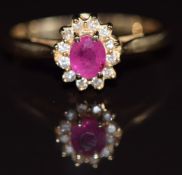 A 14k gold ring set with an oval pink sapphire surrounded by diamonds, 2.4g, size N