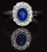 A c1920 platinum ring set with a sapphire cabochon surrounded by diamonds, 2.5g, size J