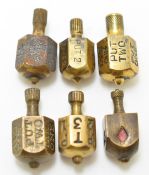 Six brass teetotums or gambling spinning tops, most for the card game put and take, one with all