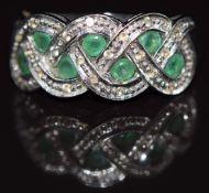 A 9ct white gold ring set with emeralds and diamonds in a plaited design, 3.5g, size N