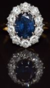 An 18ct gold ring set with an oval cut sapphire of approximately 2.5ct surrounded by ten diamonds,