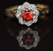 A 9ct gold ring set with a garnet surrounded by diamonds in a cluster setting, 2g, size J