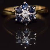 An 18ct gold ring set with a diamond surrounded by sapphires, 3.1g, size L