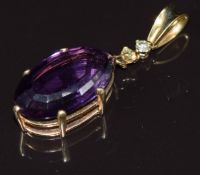 An 18ct gold pendant set with an oval cut amethyst of approximately 11.2ct and two diamonds, 6.9g