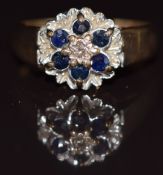 A 9ct gold ring set with a diamond and sapphires in a floral setting, 3.3g, size L
