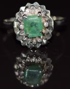 An 18ct white gold ring set with an emerald cut emerald of approximately 0.8ct and two diamonds, 2.