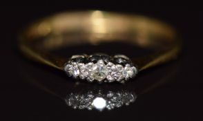 An 18ct gold ring set with three diamonds in a platinum setting, 1.8g, size M