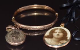 A 9ct rose gold bangle with scrolling decoration, Birmingham 1909 (7.4g), Victorian locket with