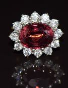 An 18ct gold ring set with an oval cut tourmaline of approximately 5.1ct surrounded by twelve