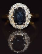 An 18ct gold ring set with an oval cut sapphire surrounded by diamonds, 5.2g, size M