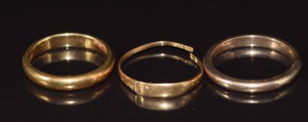 An 18ct gold wedding band/ ring (4g, size J), 9ct gold wedding band (2.5g, size L/M) and an 18ct