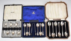 Three cased sets of hallmarked silver tea or coffee spoons comprising a feather edged set, Sheffield