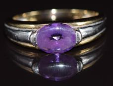 A 9ct gold bi-coloured ring set with an oval cut amethyst, 3.2g, size I