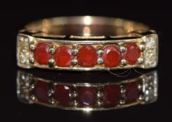 A 9ct gold ring set with five round cut garnets and diamonds, 2.8g, size N