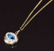 A 14k gold pendant depicting an eye on 14k gold chain, 5.7g