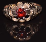 A 9ct gold ring set with a garnet, with engraved shoulders, Birmingham 1919, 2.8g, size M