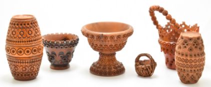Six carved coquilla nut baskets, needle cases and miniature jardinière, tallest 7cm